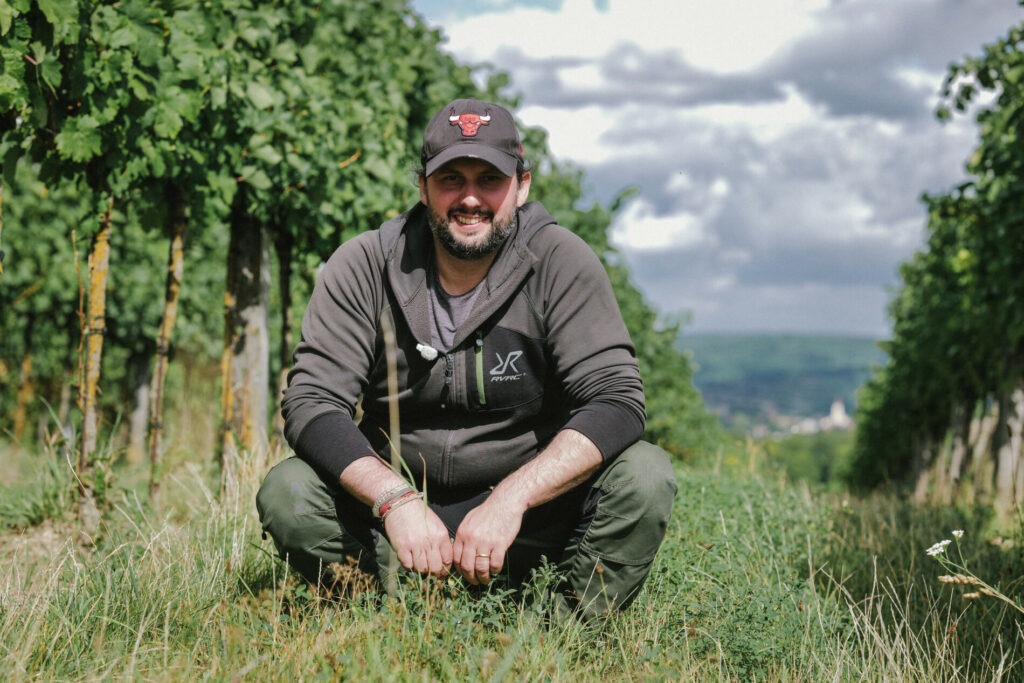 Martin Obenaus in seinem Weingarten mit Blick auf Glaubendorf