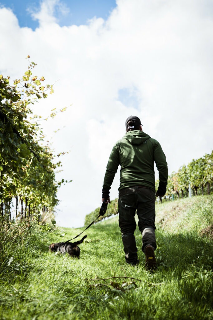 Martin Obenaus mit Hund im herbstlichen Weingarten